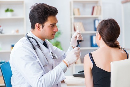 Doctor checking patients ear during medical examination